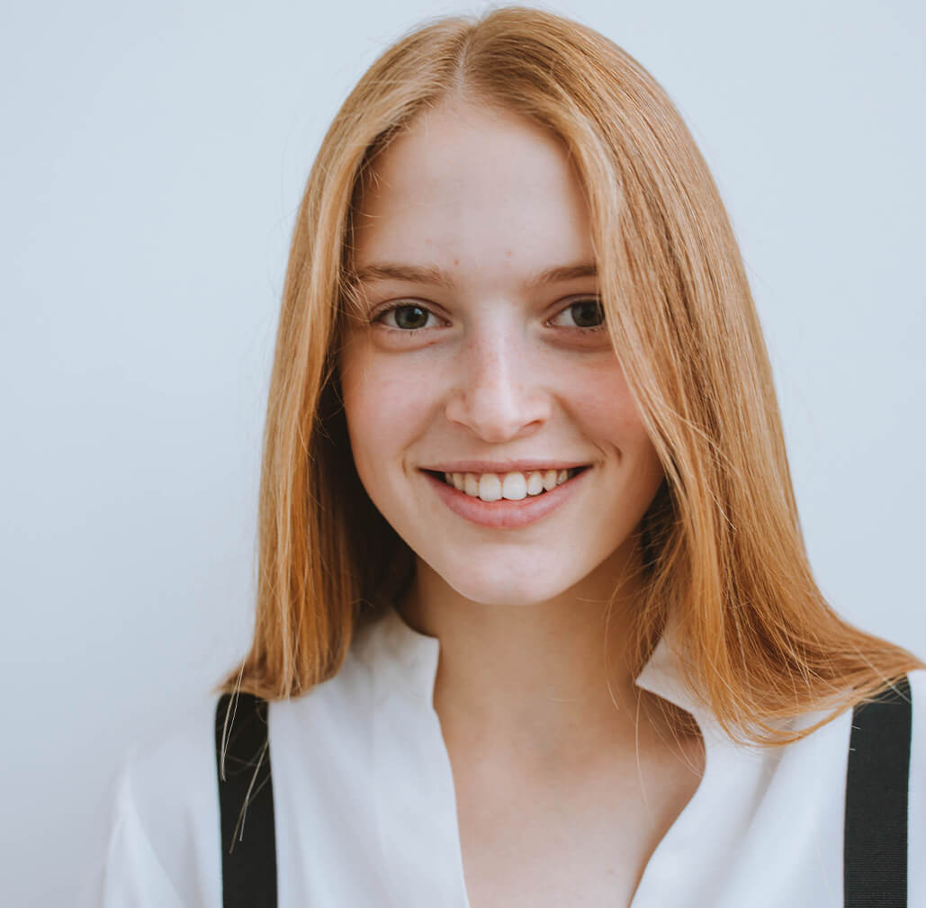 Close-up of a person's smile showing before and after results of teeth straightening.